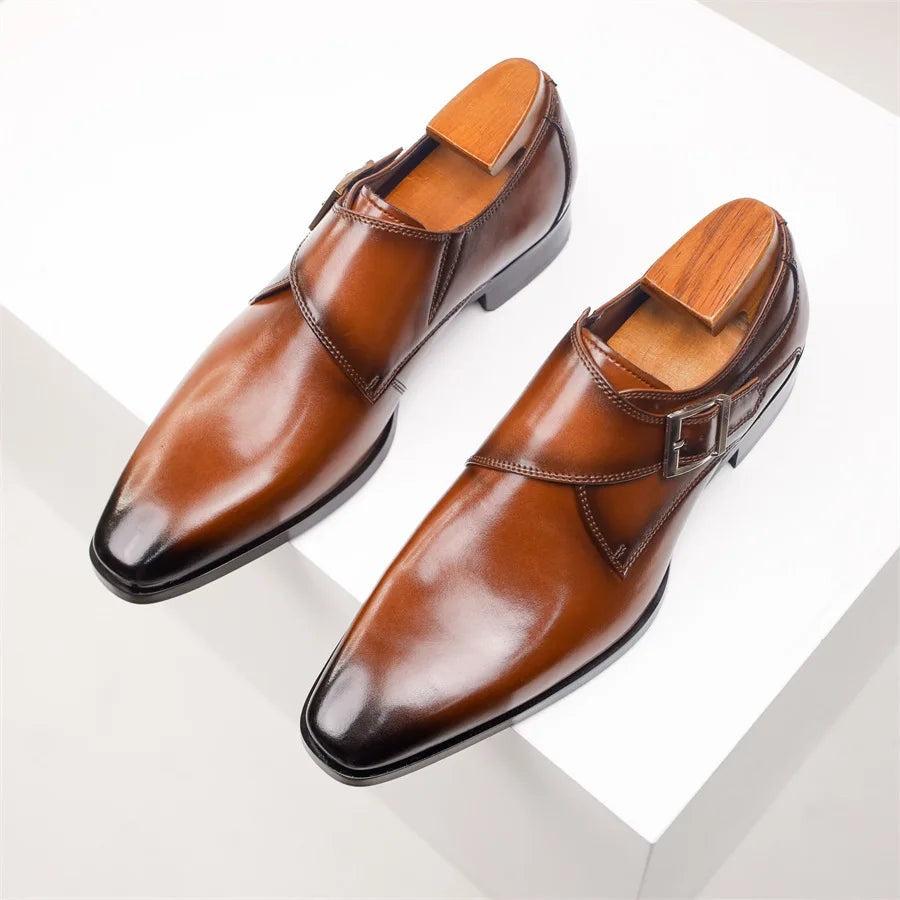 Pair of tan leather monk strap shoes viewed from above on plinth