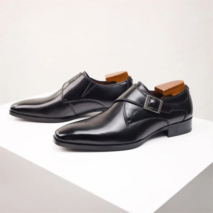 Black leather monk strap dress shoes with silver buckle and pointed toe