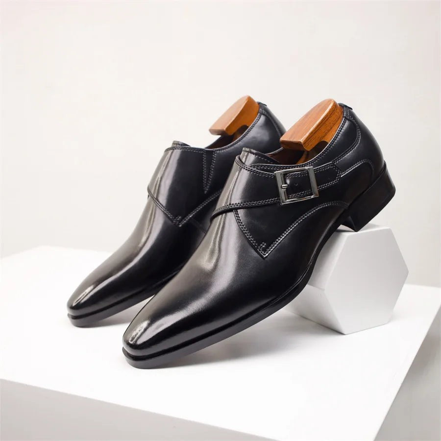 Black leather monk strap shoes displayed on angular white plinth
