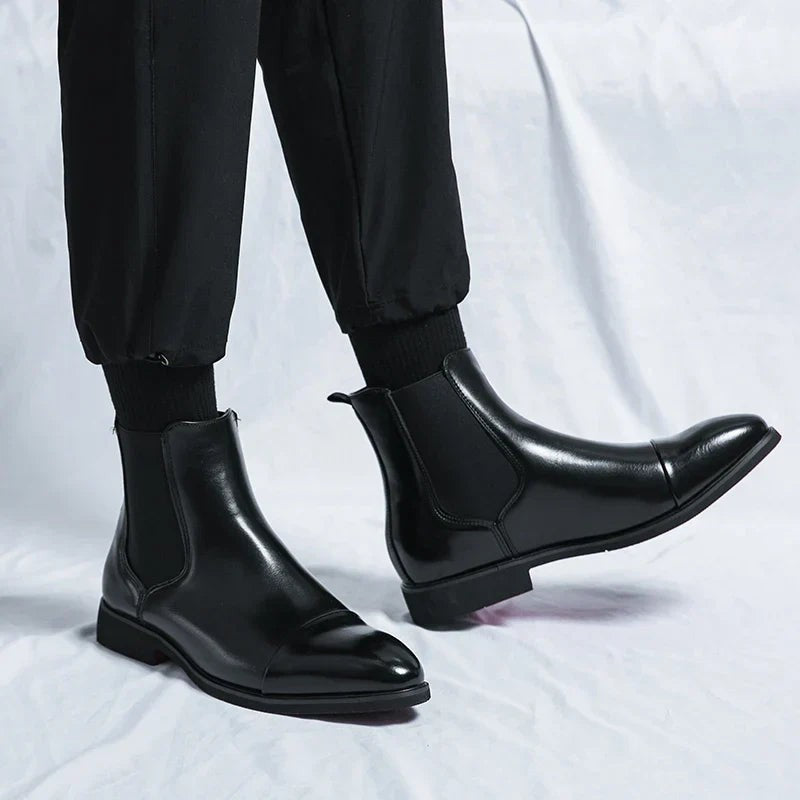 Man wearing black leather Chelsea boots styled with black joggers and socks