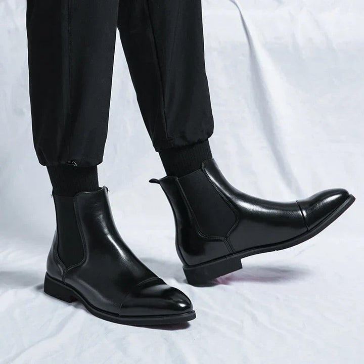 Man wearing black leather Chelsea boots styled with black joggers and socks