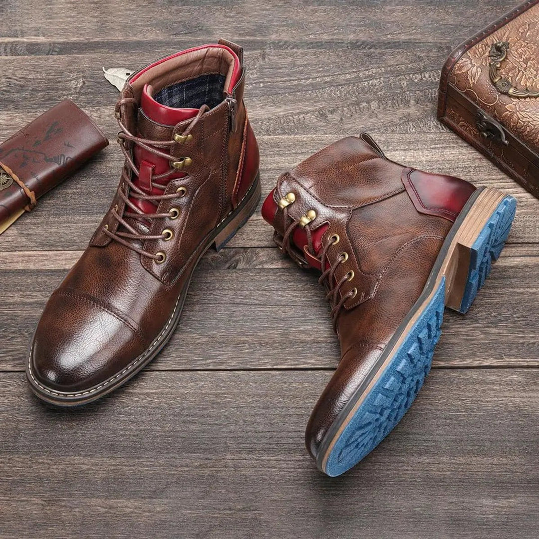 Pair of cap-toe leather ankle boots showing textured blue rubber sole