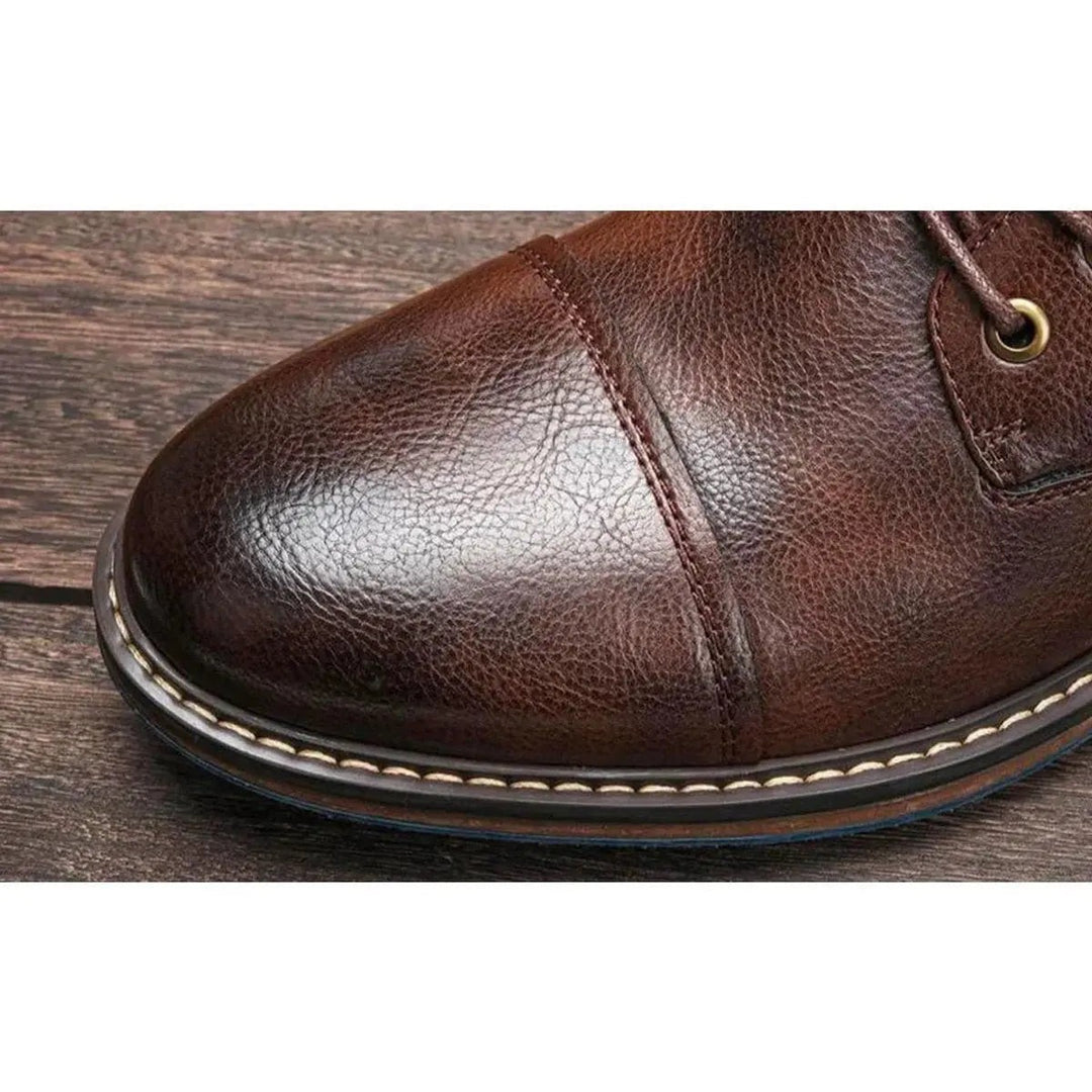 Close-up of stitched cap-toe on brown leather lace-up ankle boot