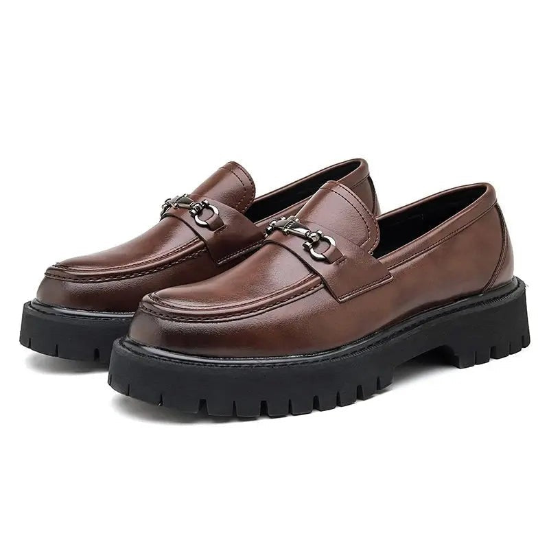 Pair of brown leather loafers with horsebit buckle, shown against white background