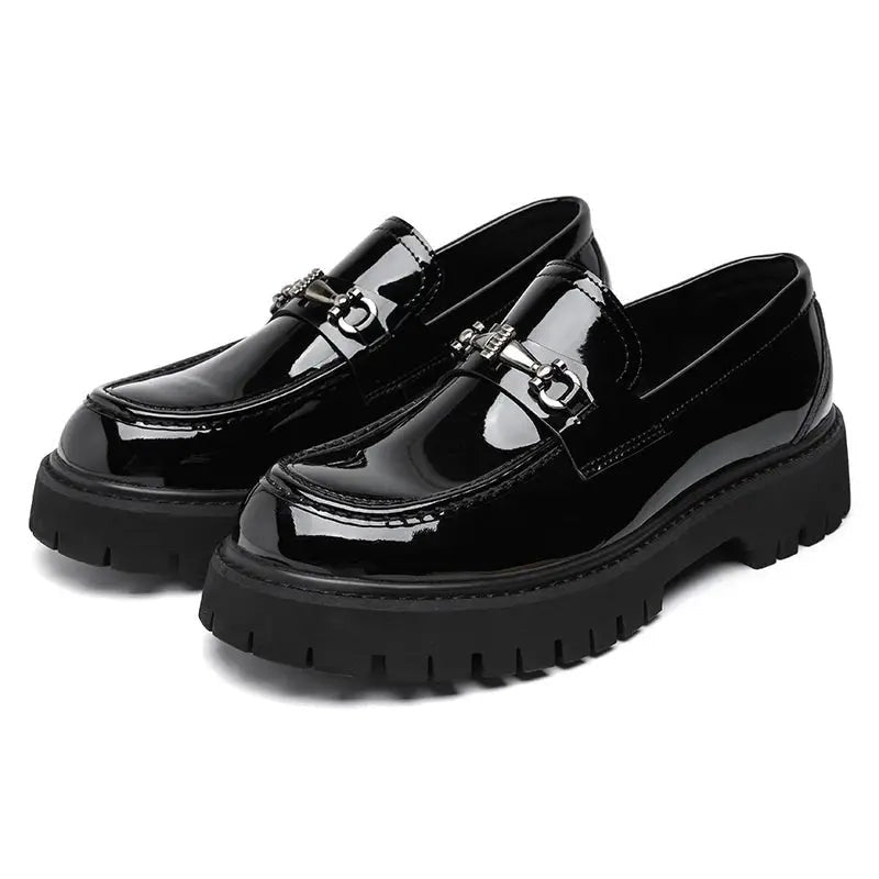 Pair of glossy black patent leather loafers with silver buckle, platform sole visible