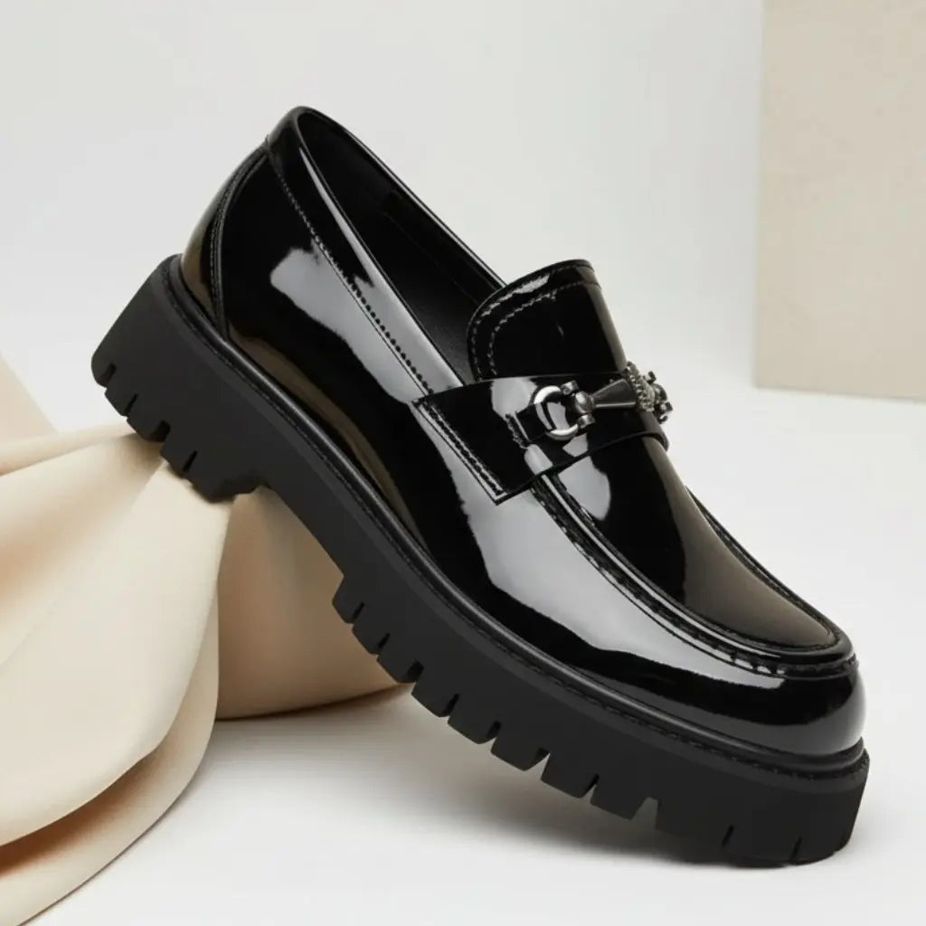 Glossy black patent leather loafer with silver buckle and heavy-duty platform sole