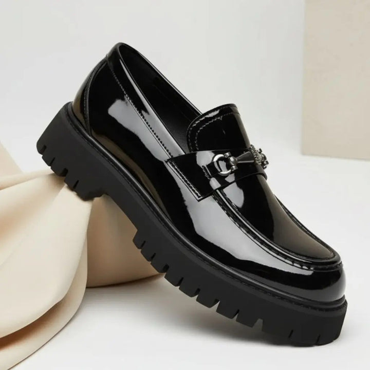 Glossy black patent leather loafer with silver buckle and heavy-duty platform sole