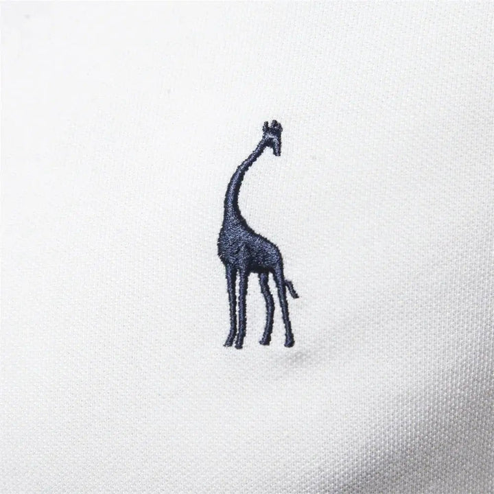 Close-up of navy giraffe embroidery on white polo shirt chest fabric