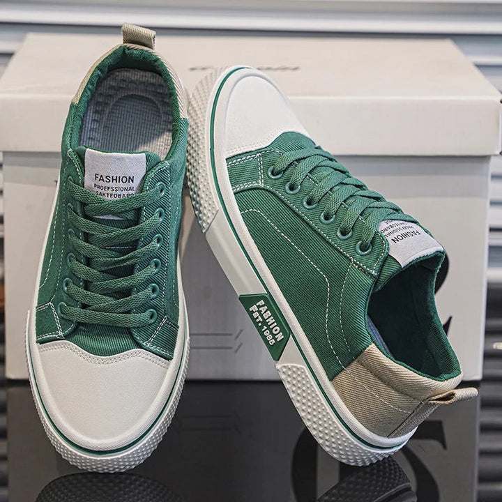 Green canvas lace-up sneakers featuring white toe caps and beige contrast panels