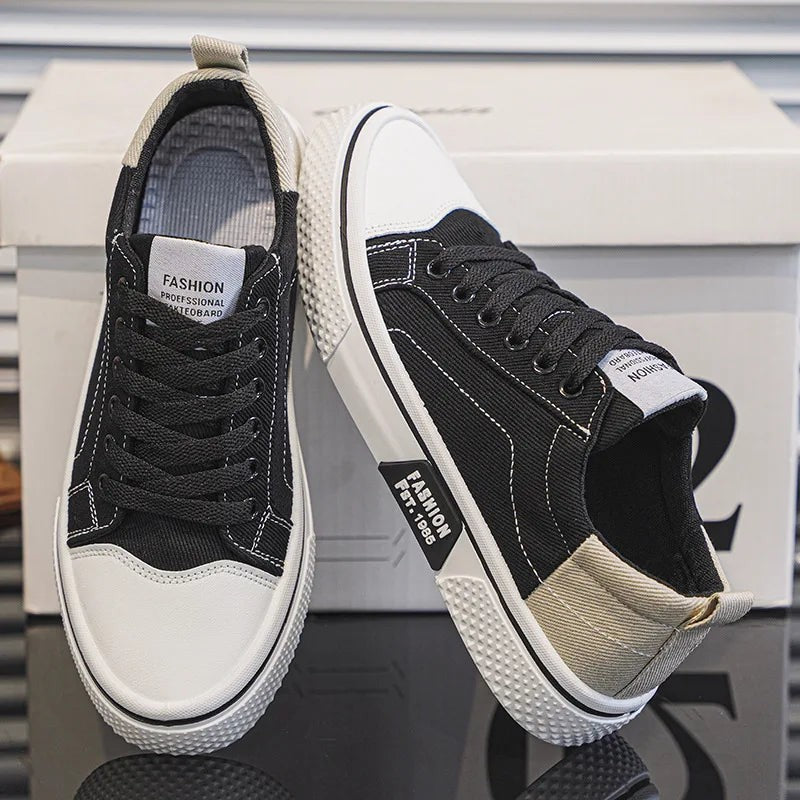 Black canvas lace-up sneakers with white toe caps and contrast stitching detail