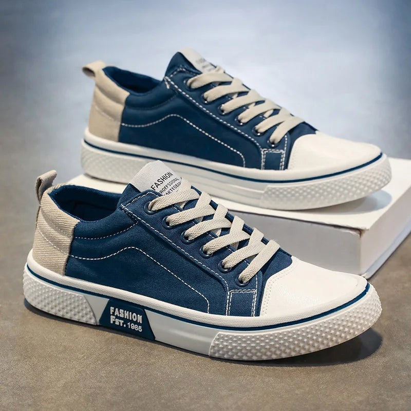 Navy blue low-top canvas trainers with beige panels and chunky white soles