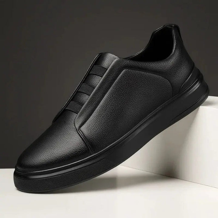 All-black leather slip-on trainers with subtle elastic loop lacing detail