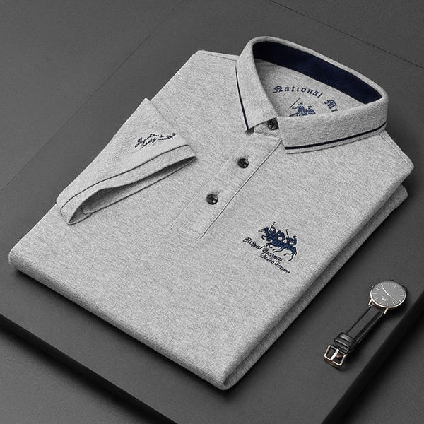 Grey marl men's polo shirt folded with navy-trimmed collar and embroidered crest