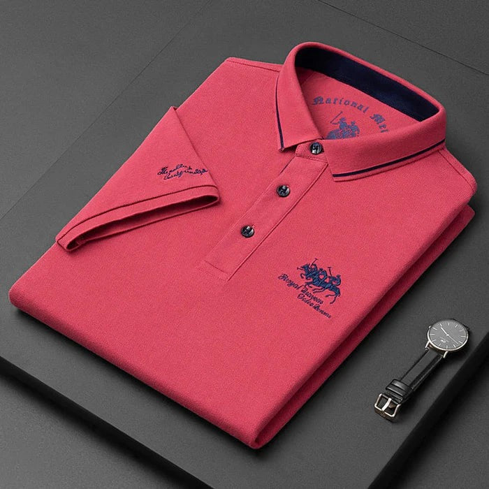 Coral pink men's polo shirt folded with navy-striped collar and embroidered logo