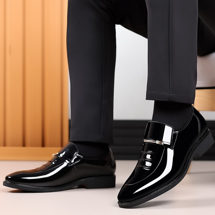 Man wearing black patent leather loafers with black socks and trousers
