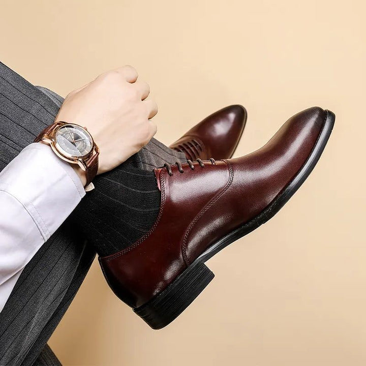 Man in grey pinstripe trousers wearing burgundy leather lace-up dress shoe