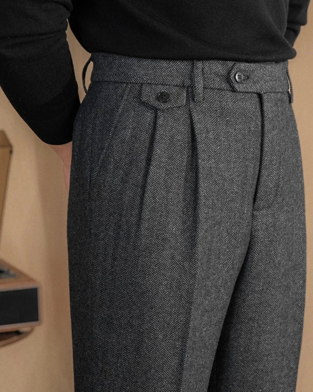 Grey herringbone tweed trousers with pleated front and buttoned side tab detail