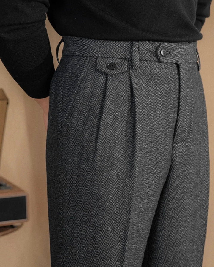 Grey herringbone tweed trousers with pleated front and buttoned side tab detail