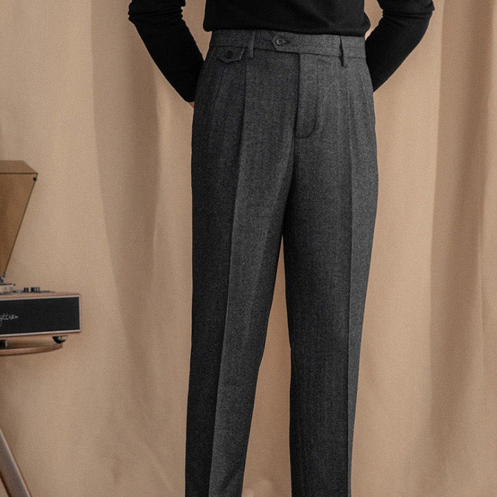 Charcoal herringbone trousers styled with pleated front and tapered leg silhouette