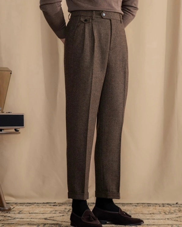 Brown herringbone trousers with turn-up hems paired with tasselled loafers