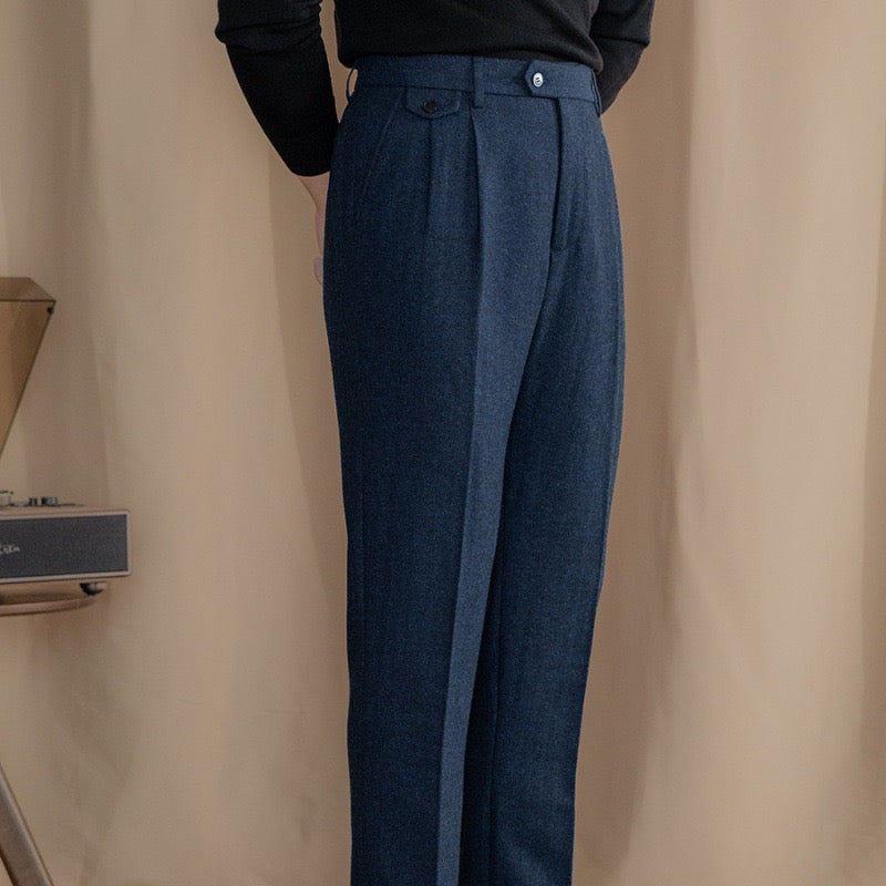 Navy herringbone tweed trousers showing tailored fit with high-rise pleated waist