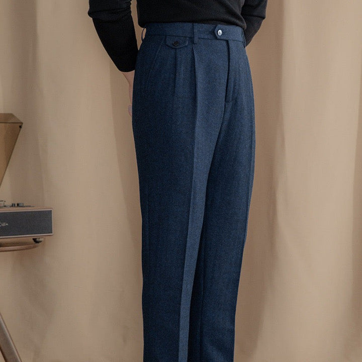 Navy herringbone tweed trousers showing tailored fit with high-rise pleated waist