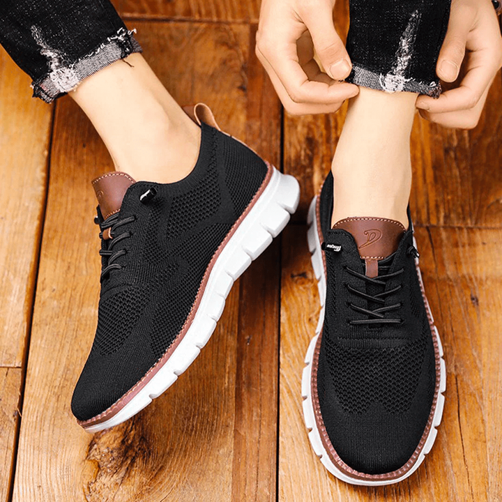Black knit lace-up trainers worn with white ridged sole and tan trim
