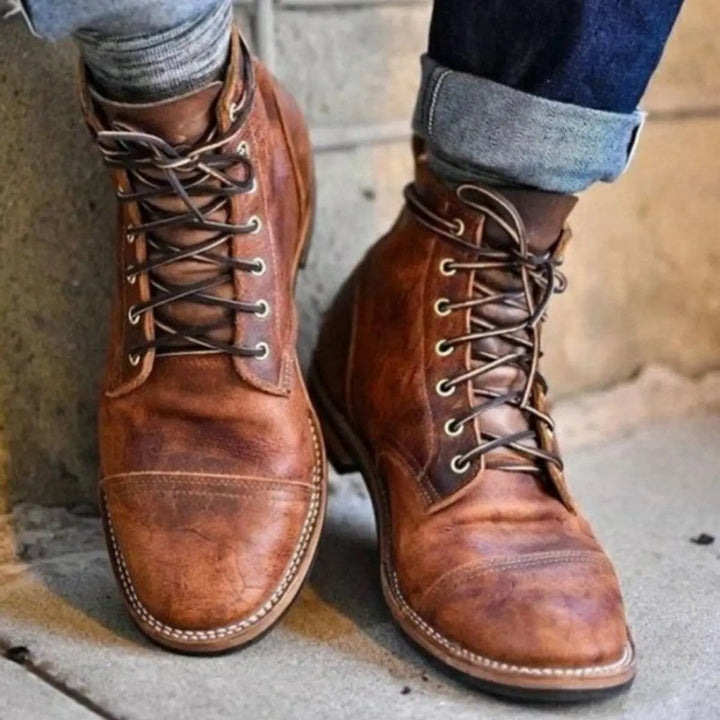 Tan leather lace-up cap-toe ankle boots worn with rolled denim jeans