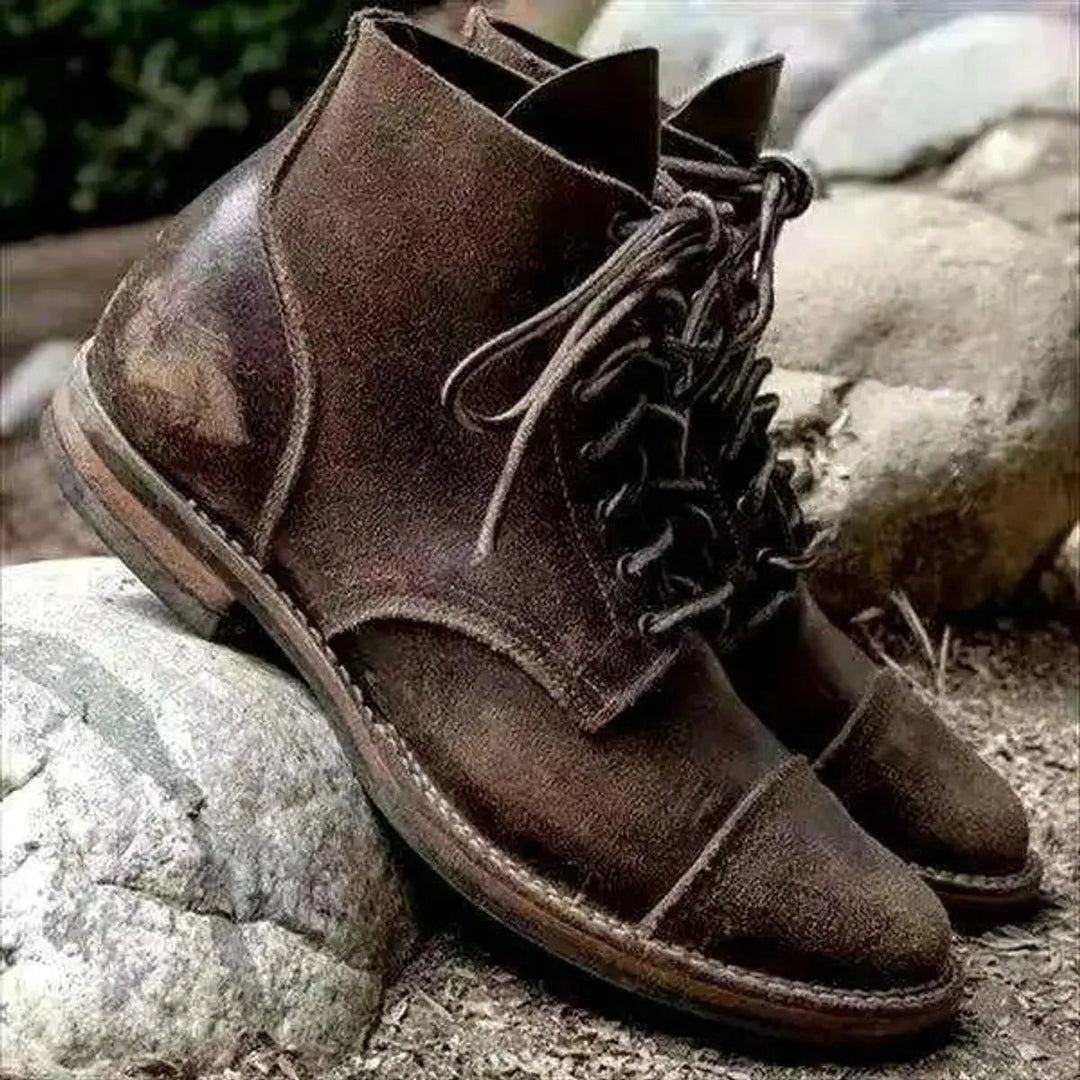Weathered brown leather ankle boots showing rugged cap-toe detailing