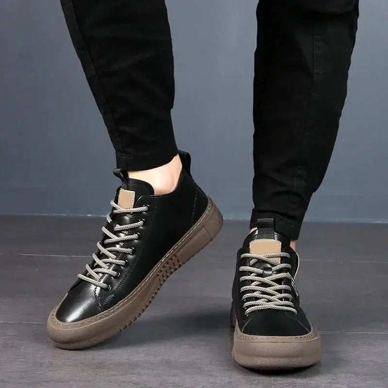 Close-up of black lace-up high-top trainers worn with black joggers