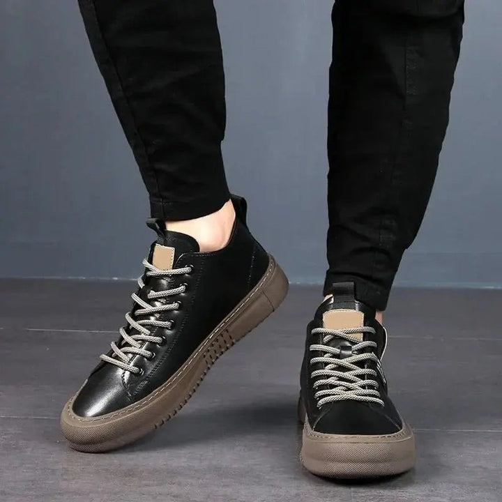 Close-up of black lace-up high-top trainers worn with black joggers