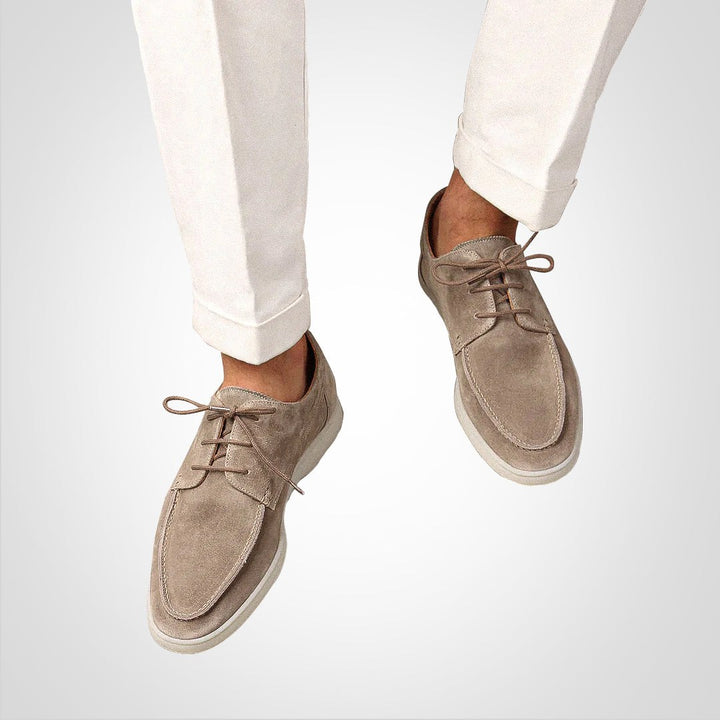 Man styling taupe suede lace-up loafers with cream turned-up trousers