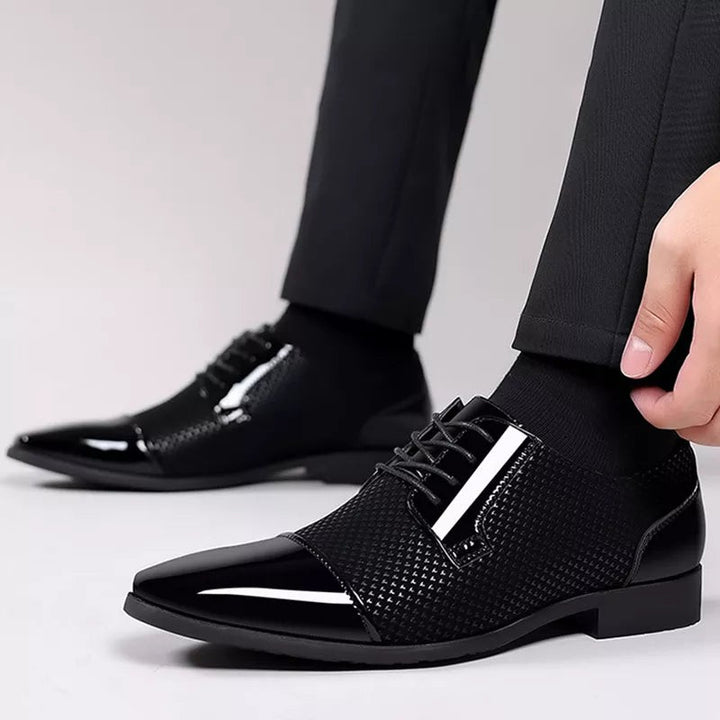 Black patent leather Oxford shoes with subtle textured panel worn on foot