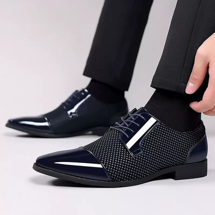 Navy patent Oxford shoes with textured overlay and pointed toe, worn on foot