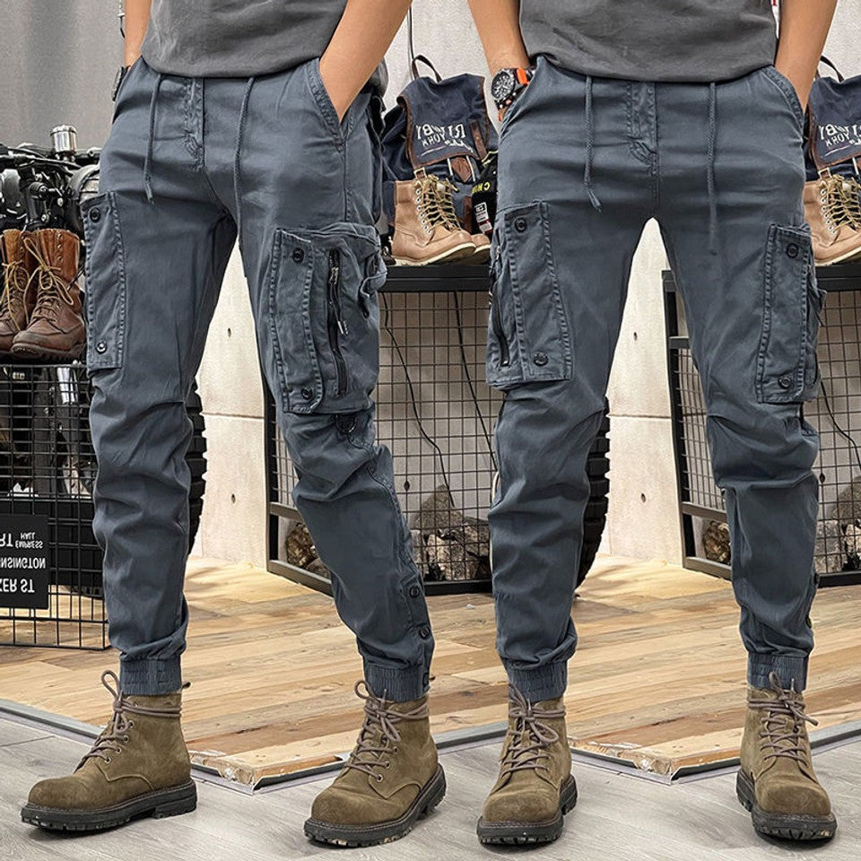 Grey cargo trousers featuring zip pocket detail and elasticated cuffed hems