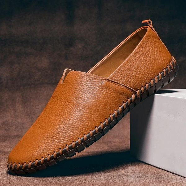 Tan pebbled-grain leather loafers featuring hand-stitched rubber sole