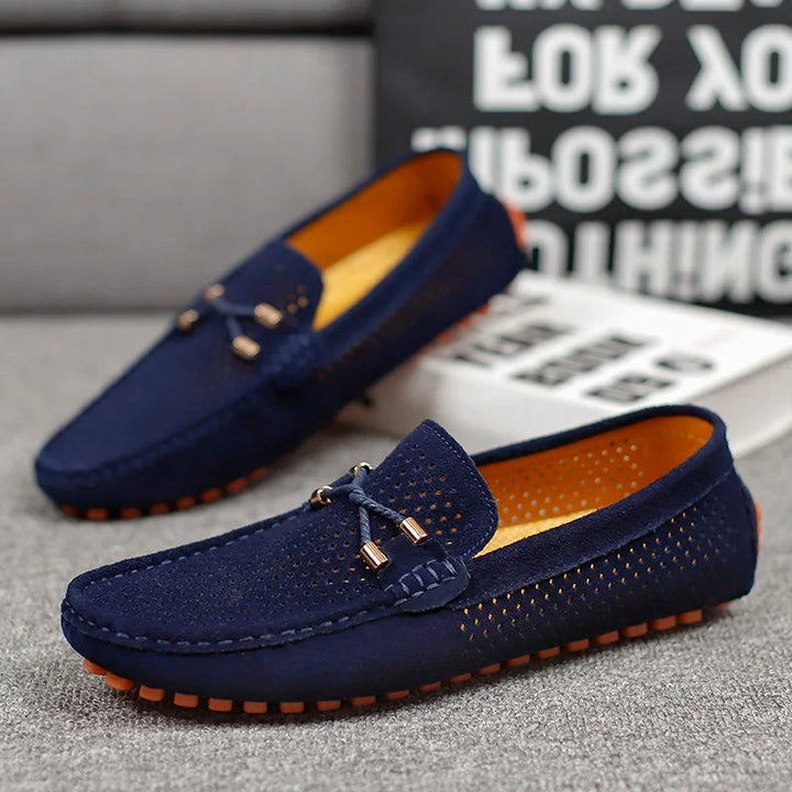 Navy suede perforated loafers displayed as a pair with orange sole