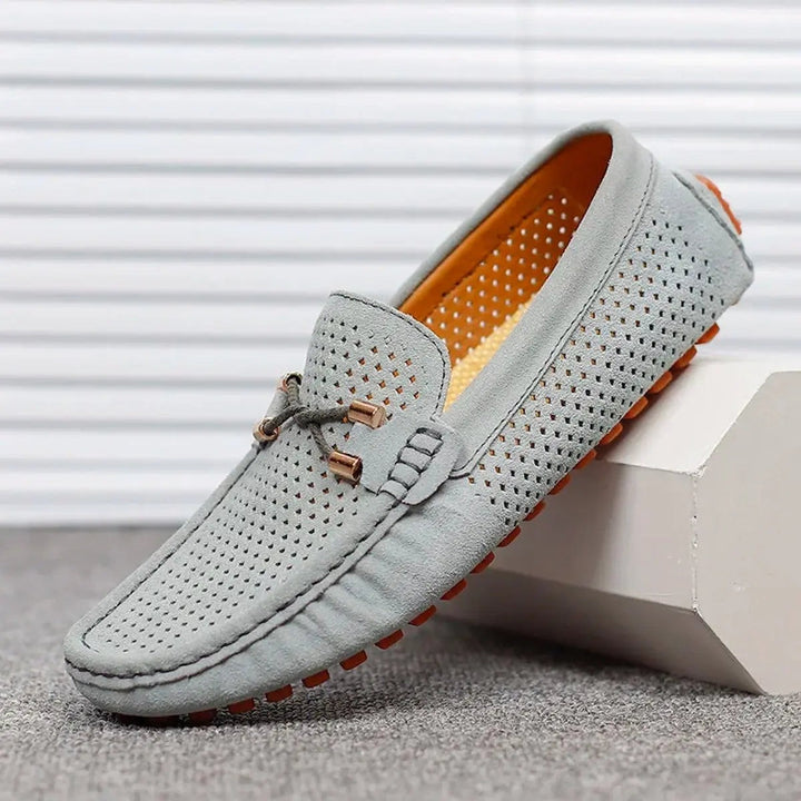 Grey suede driving loafers featuring bow trim and orange contrast sole