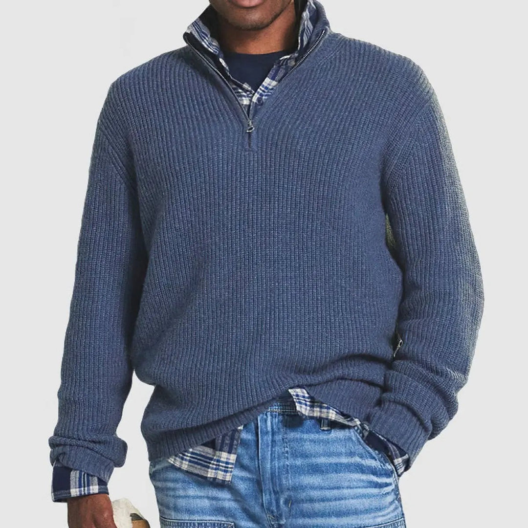 Slate blue ribbed quarter-zip jumper layered over plaid shirt and denim