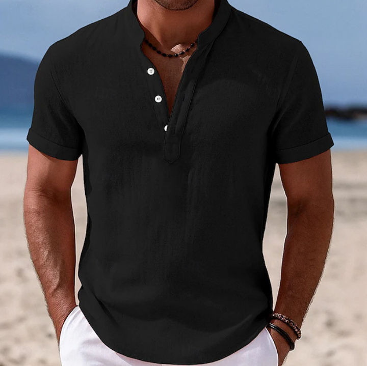 Black grandad-collar linen-blend shirt with button placket, worn on a beach