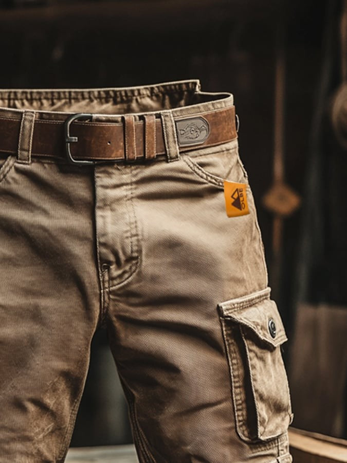 Close-up of beige cargo shorts showing belt buckle and orange brand tag