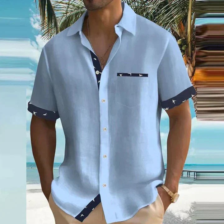 Pale blue short-sleeve shirt featuring navy bird-print cuffs and collar placket