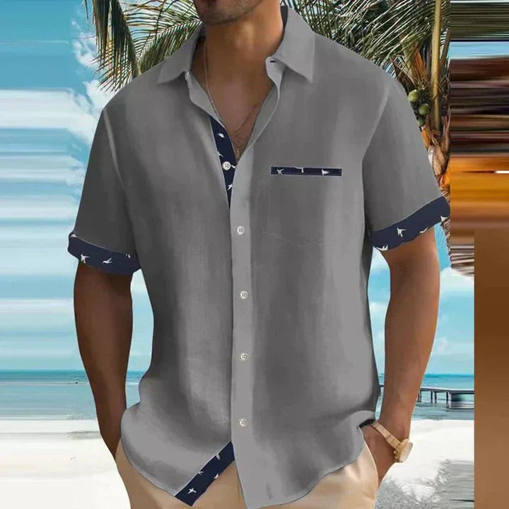 Grey short-sleeve shirt with navy bird-print cuffs and chest pocket detail