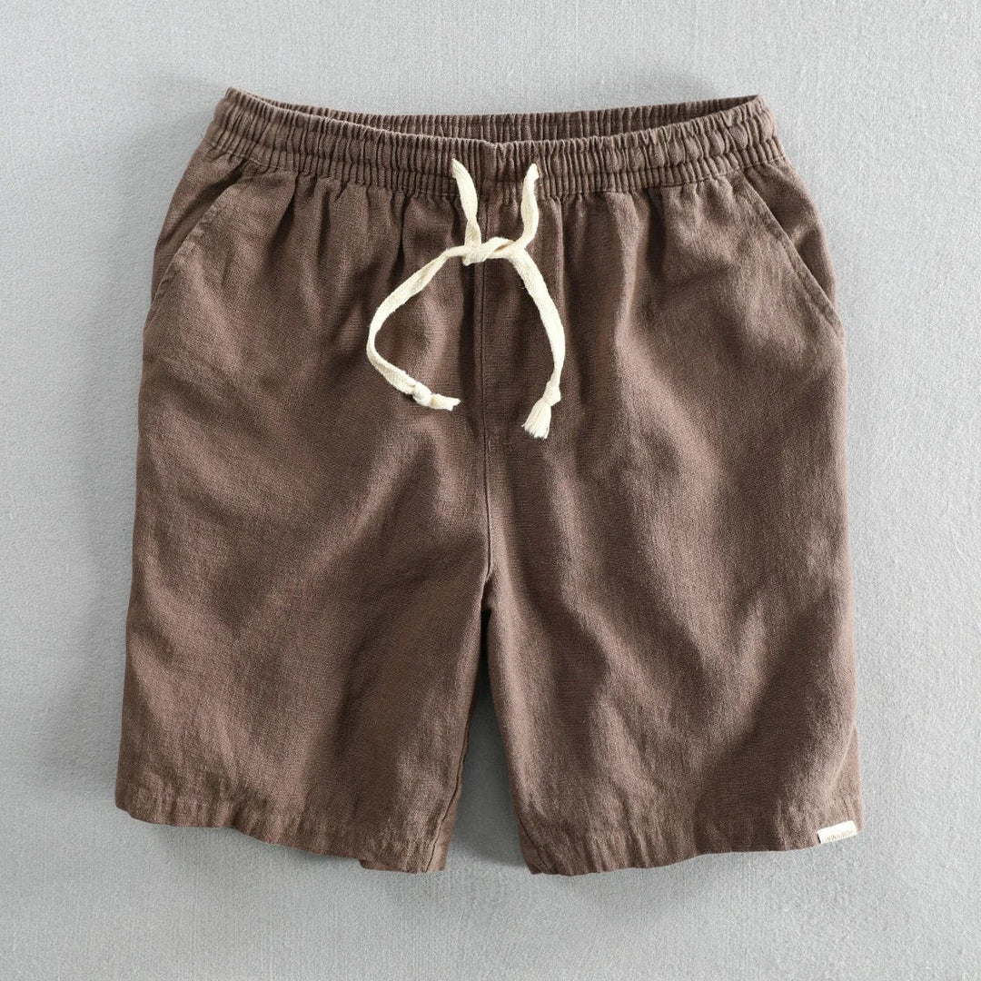 Dark brown linen shorts featuring elastic waistband and cream drawstring