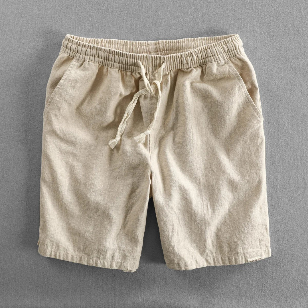Beige linen shorts featuring relaxed fit and elasticated drawstring waist