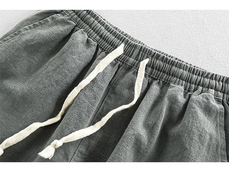Close-up of grey linen shorts showing elasticated waistband and drawstring ties