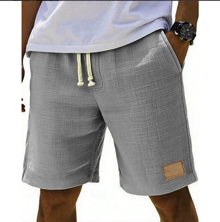 Grey textured linen shorts featuring elasticated drawstring and tan patch