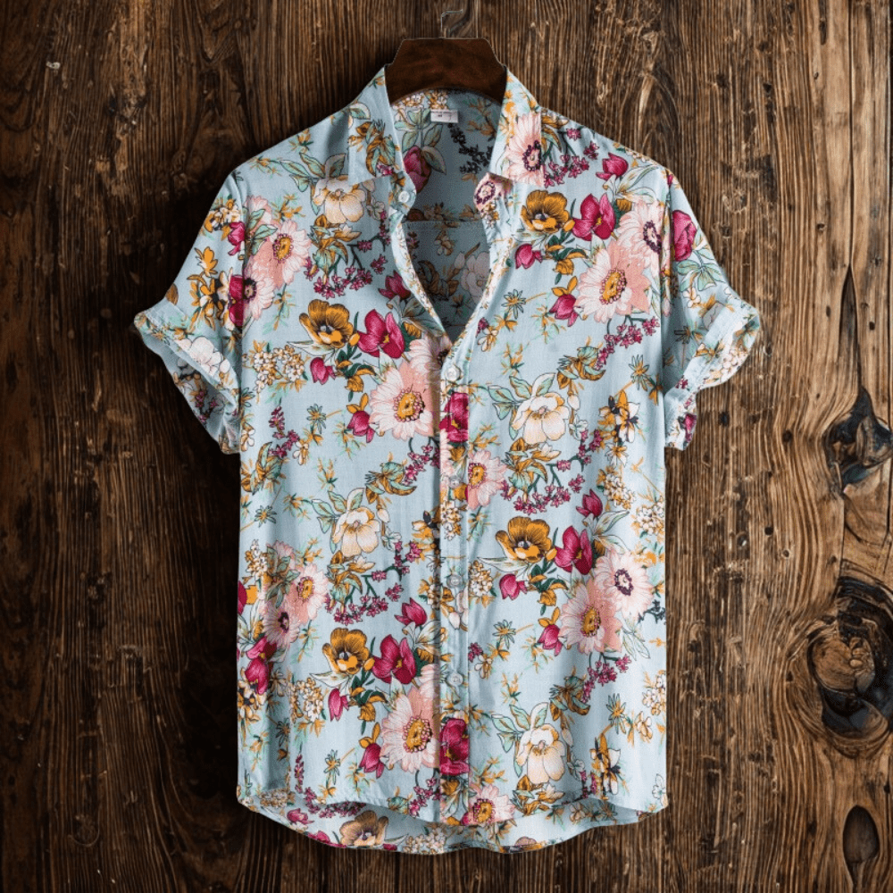 Men's short-sleeve floral shirt in pale blue with button-down front, hung against wood