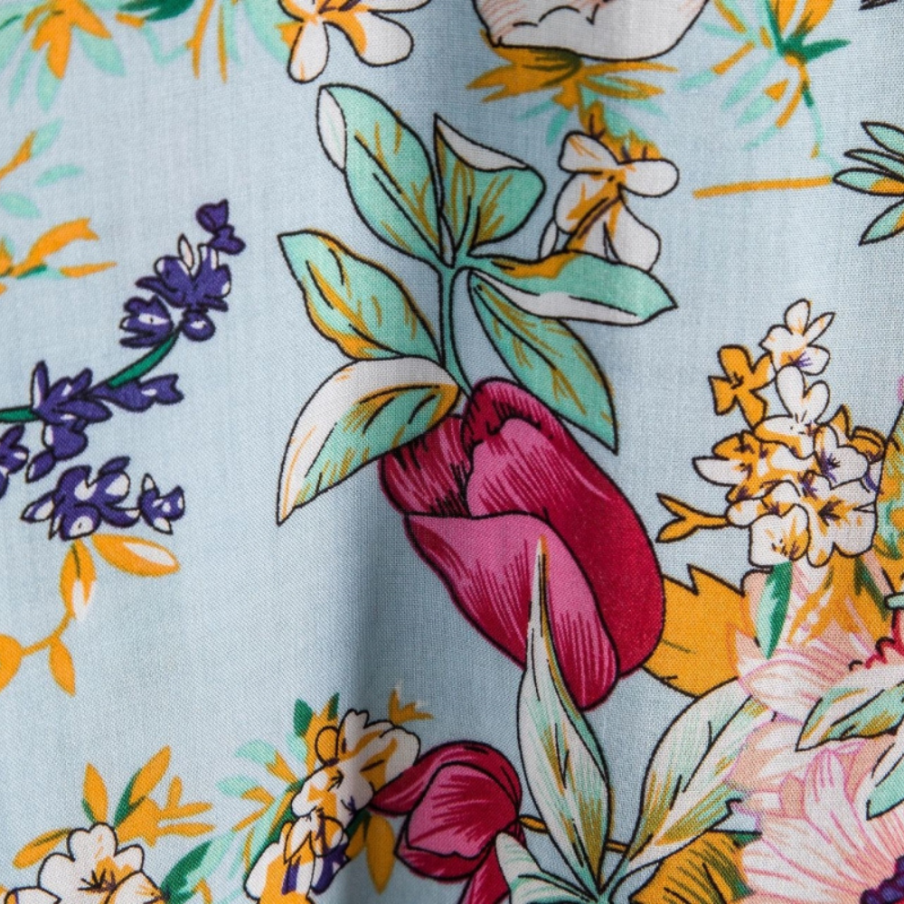 Detailed close-up of tulip and blossom print fabric on men's floral shirt