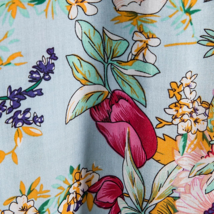 Detailed close-up of tulip and blossom print fabric on men's floral shirt